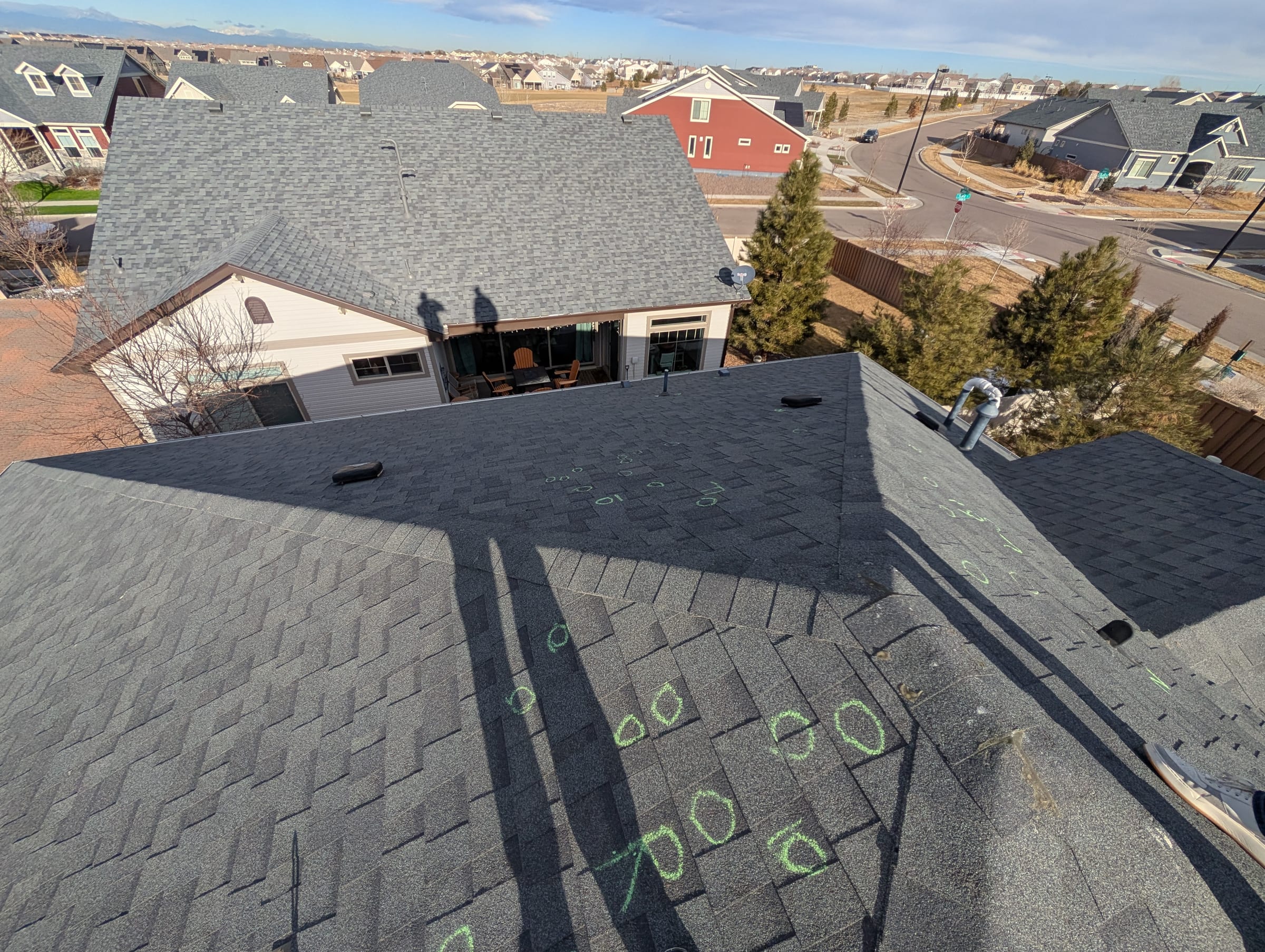 Asphalt shingle roof with chalk inspection markings for hail claim review