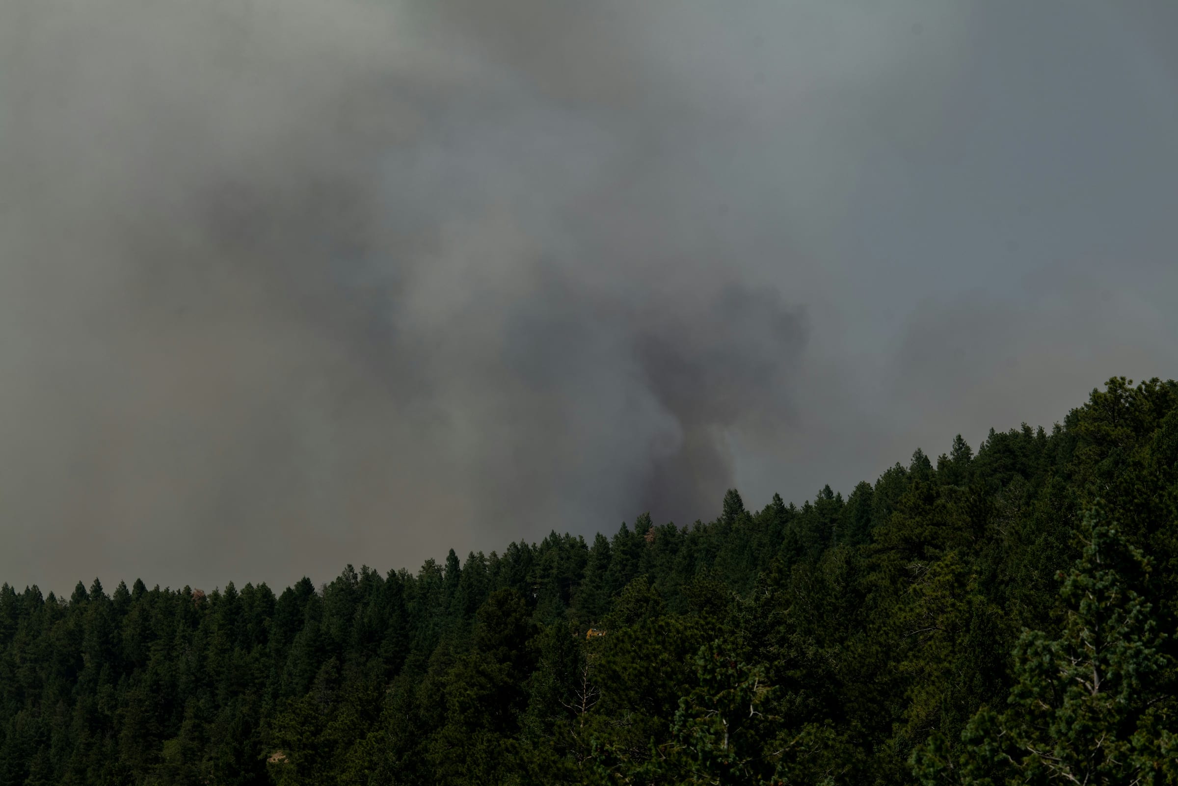 Colorado wildfire smoke over mountain forest